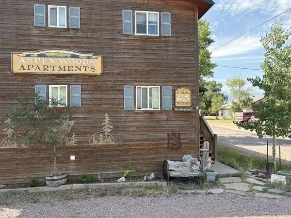 a brick building with a bench and potted plants