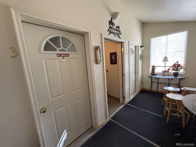 a view of a hallway with workspace and a window