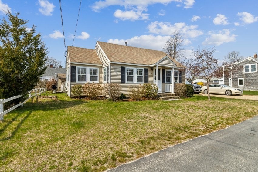 a front view of house with yard and trees around