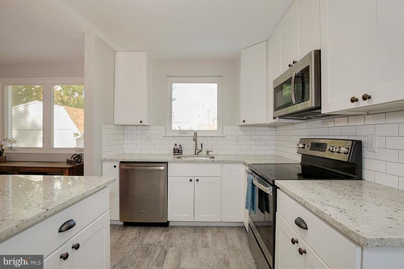 3807 Jeffry Street Silver Spring, MD 20906 - Photo 12 of 26 a kitchen with stainless steel appliances granite countertop a sink stove and microwave