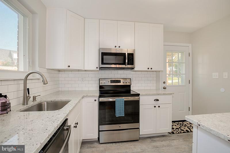 3807 Jeffry Street Silver Spring, MD 20906 - Photo 14 of 26 a kitchen with granite countertop a stove and a sink