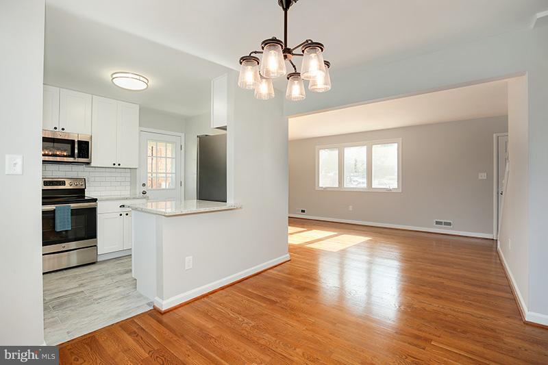 3807 Jeffry Street Silver Spring, MD 20906 - Photo 8 of 26 a view of a kitchen with wooden floor and stainless steel appliances