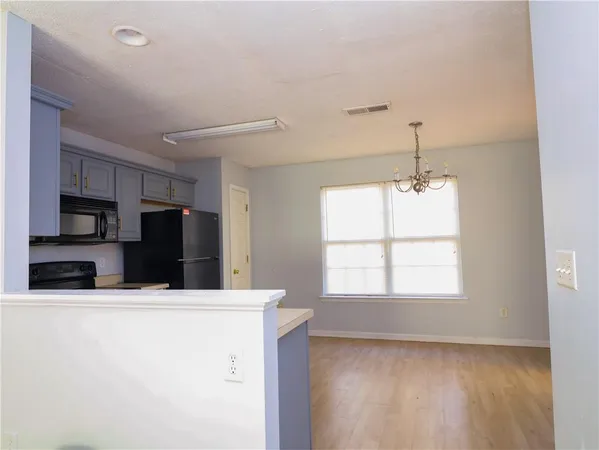 a kitchen with stainless steel appliances wooden floor and a refrigerator