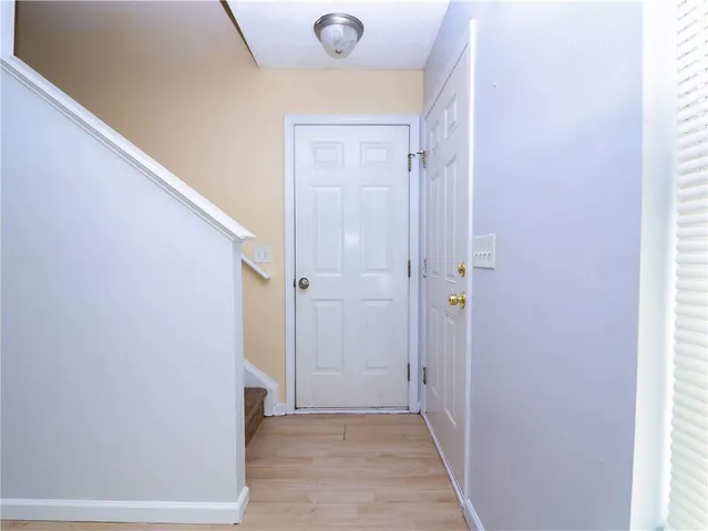a view of a hallway with wooden floor and closet