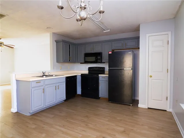 a kitchen with stainless steel appliances granite countertop a refrigerator a sink a stove a microwave and wooden floors