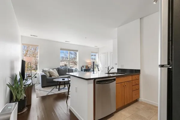 a kitchen with granite countertop white cabinets and stainless steel appliances