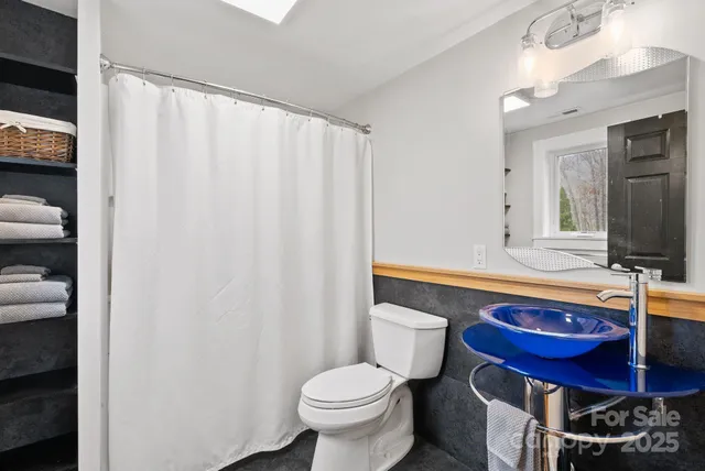 a bathroom with a toilet a sink and a mirror