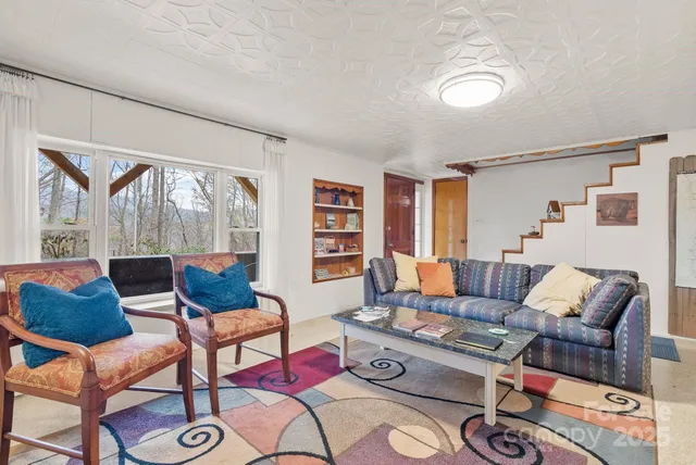 a living room with furniture and a floor to ceiling window