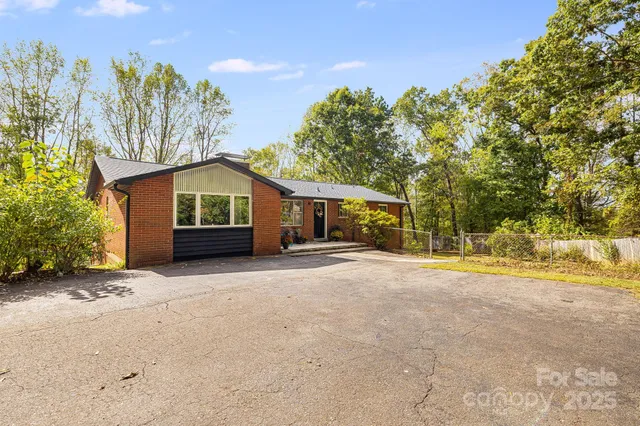 a view of a house with a yard and potted plants
