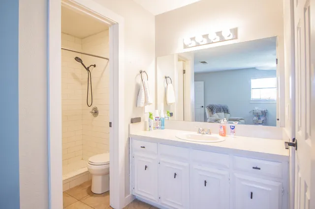a bathroom with a sink a toilet and a large mirror
