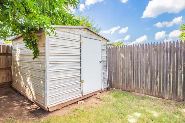 a view of a house with a backyard and wooden fence