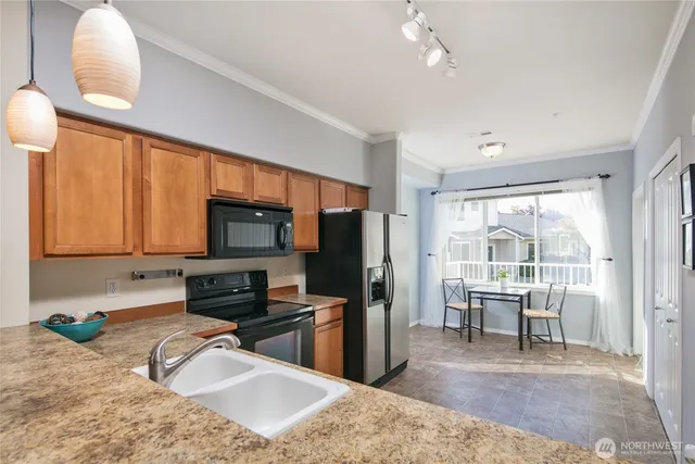 a kitchen with granite countertop a stove refrigerator and microwave