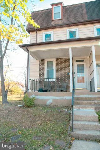 a view of a house with a small yard and floor to ceiling window and plants