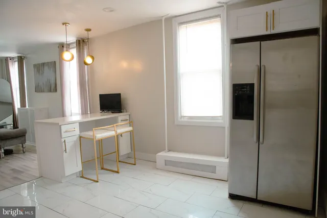 a kitchen with a sink and chairs
