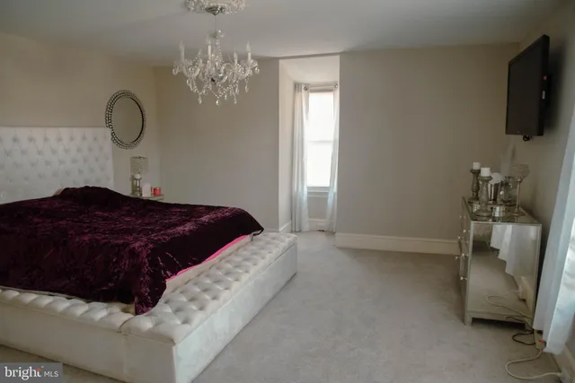 a bedroom with a bed mirror and couch