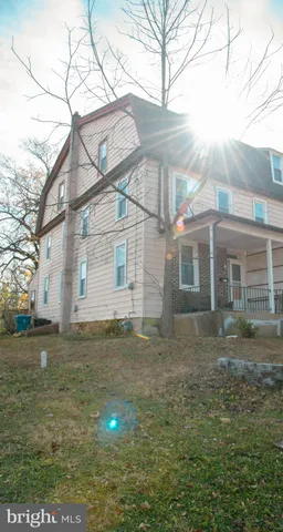 a view of a yard in front of a house with large tree