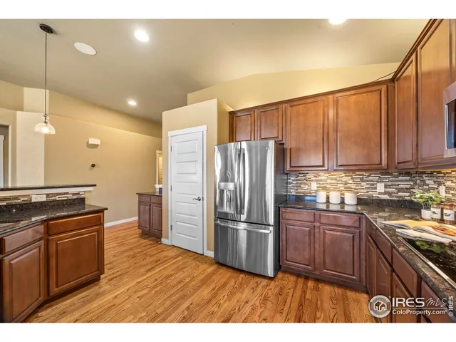 a kitchen with granite countertop a refrigerator stove and sink