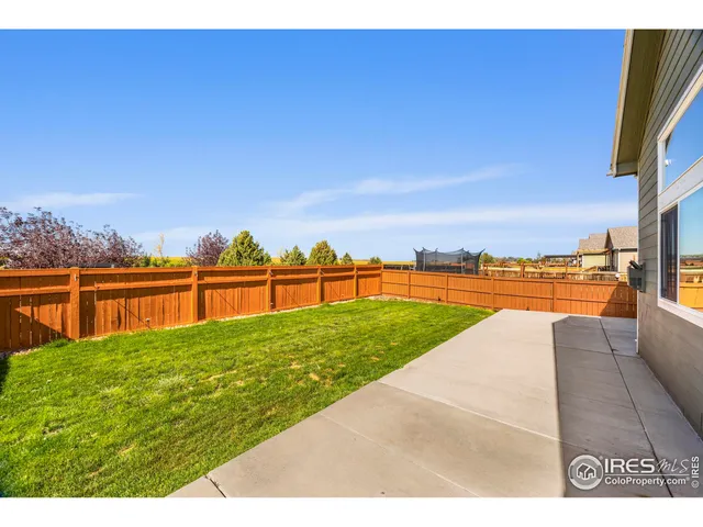 a front view of house with yard and trees in the background