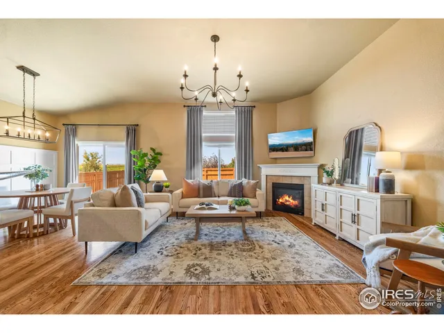 a living room with furniture a fireplace and a chandelier