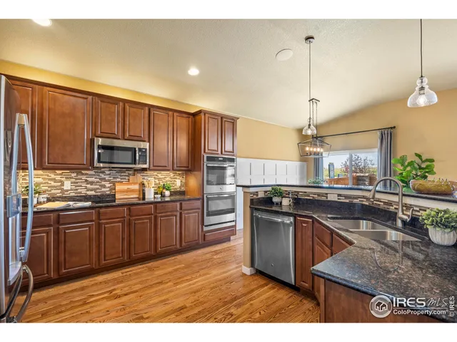 a kitchen with stainless steel appliances granite countertop wooden cabinets a stove a sink and a granite counter top