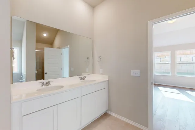 a bathroom with a double vanity sink and a mirror