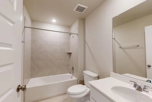 a bathroom with a bathtub shower sink vanity and toilet
