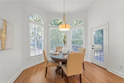a dining room with furniture a chandelier and wooden floor
