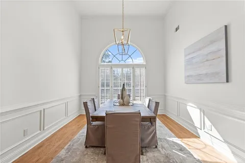 a dining room with furniture a chandelier and wooden floor