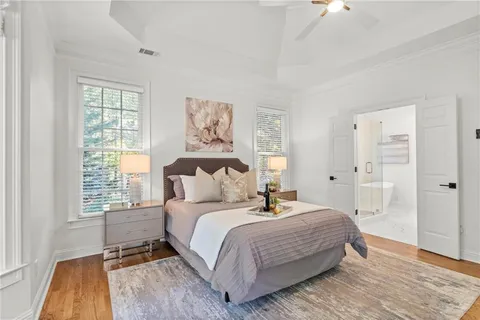 a bedroom with a bed a couch and a large window