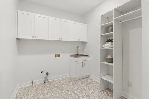 an empty room with chandelier fan and windows