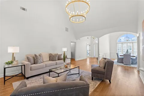 a living room with furniture a dining table and a chandelier