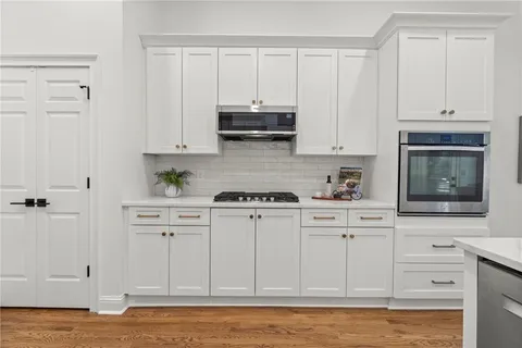 a kitchen with white cabinets and sink
