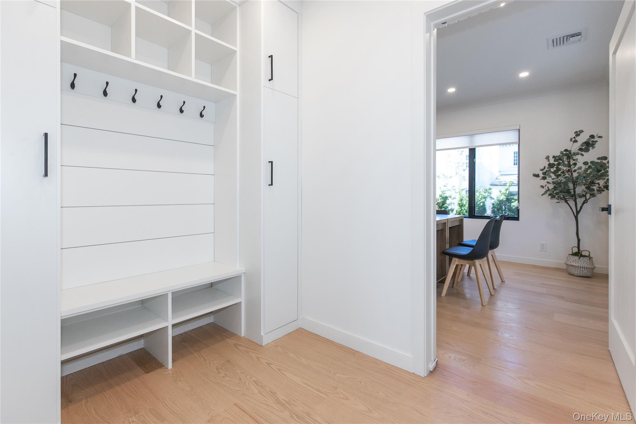 1 Bentley Road Great Neck, NY 11023 - Photo 17 of 34 a view of a hallway with wooden floor and a potted plant