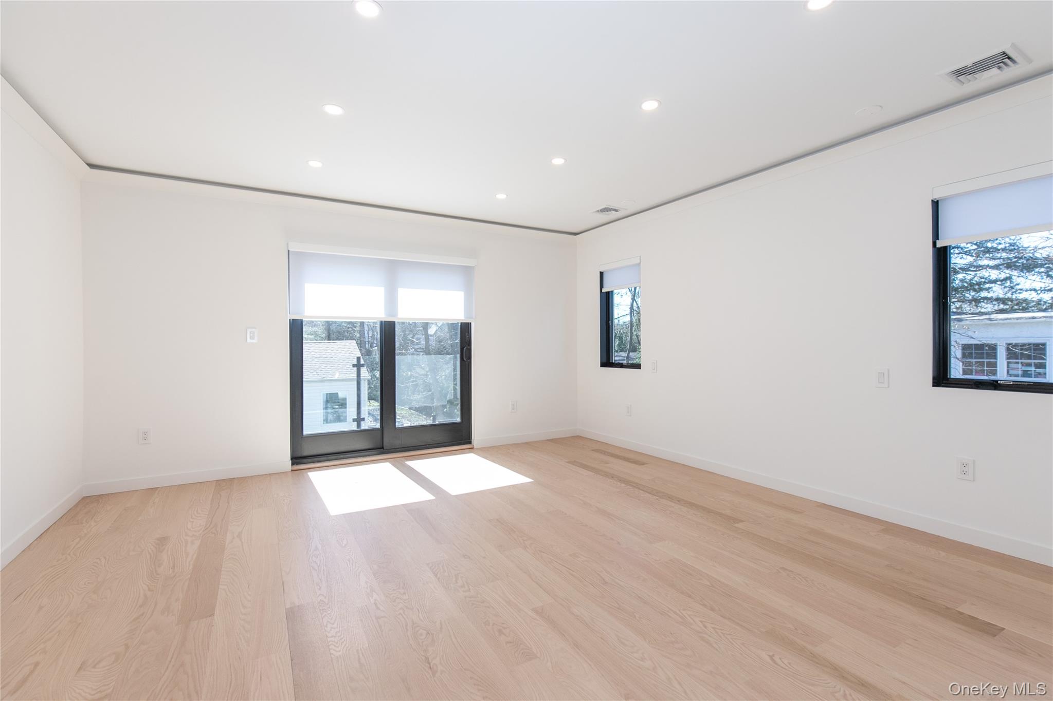 1 Bentley Road Great Neck, NY 11023 - Photo 19 of 34 an empty room with wooden floor and windows