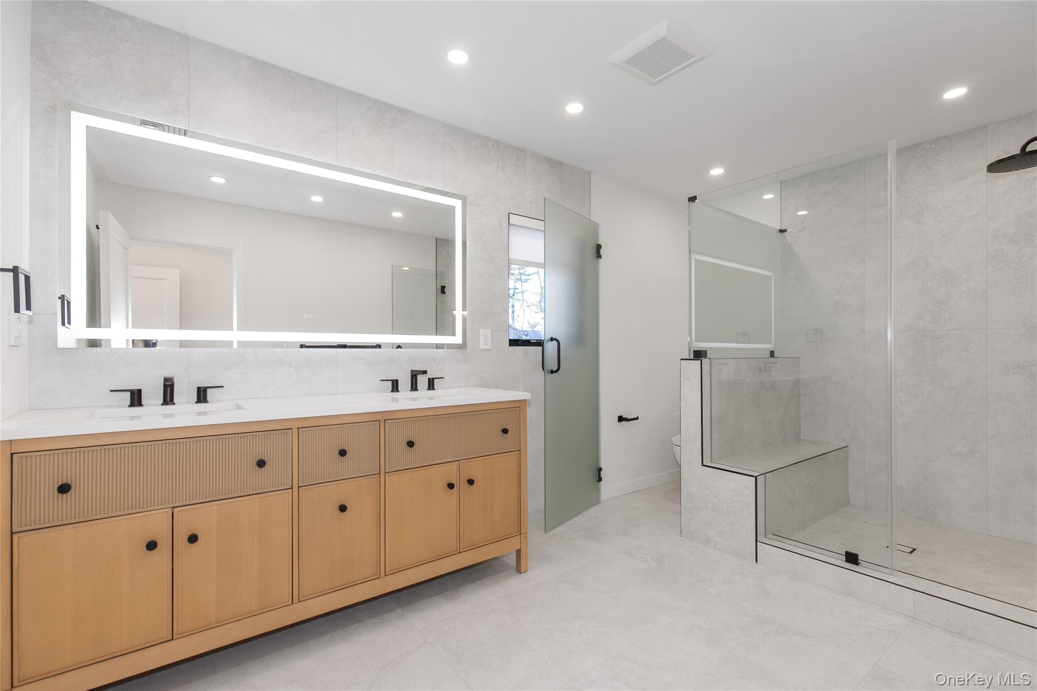 1 Bentley Road Great Neck, NY 11023 - Photo 21 of 34 a bathroom with a double vanity sink mirror and shower