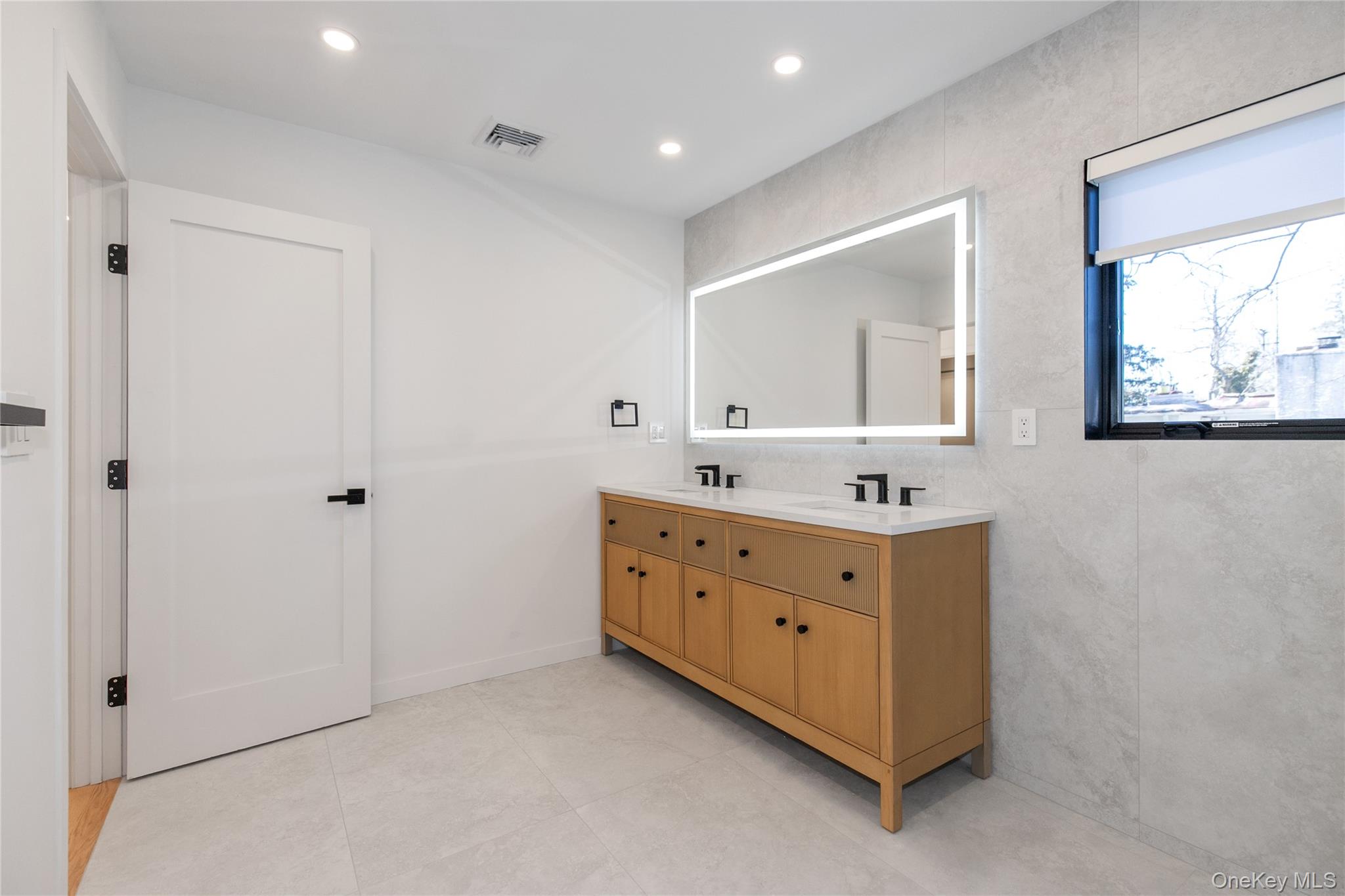 1 Bentley Road Great Neck, NY 11023 - Photo 22 of 34 a bathroom with a double vanity sink and mirror