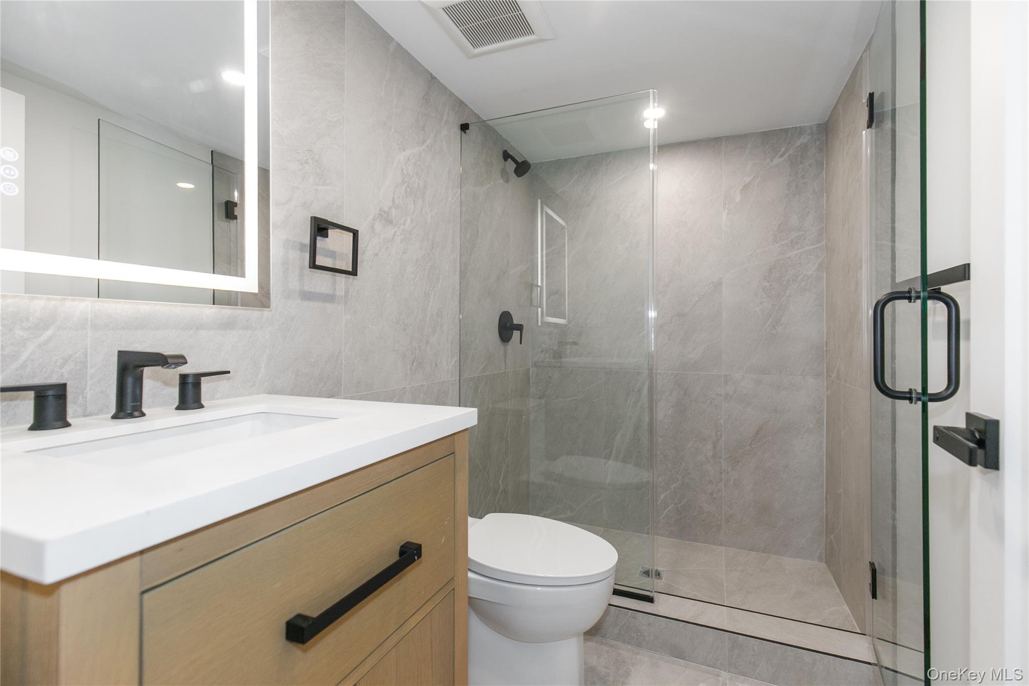 1 Bentley Road Great Neck, NY 11023 - Photo 26 of 34 a bathroom with a sink a toilet and shower