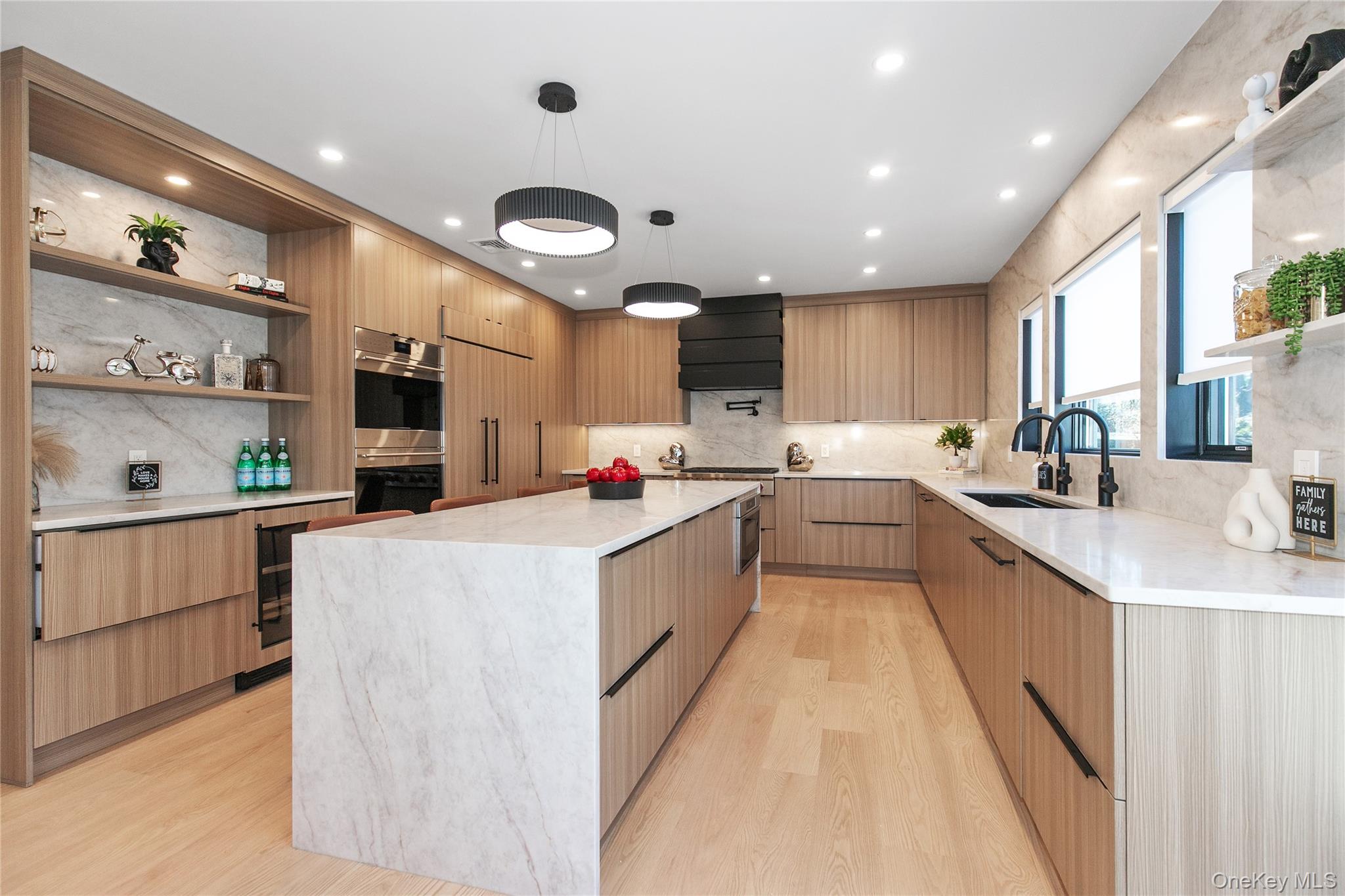 1 Bentley Road Great Neck, NY 11023 - Photo 9 of 34 a large white kitchen with kitchen island a sink a center island stainless steel appliances and a window