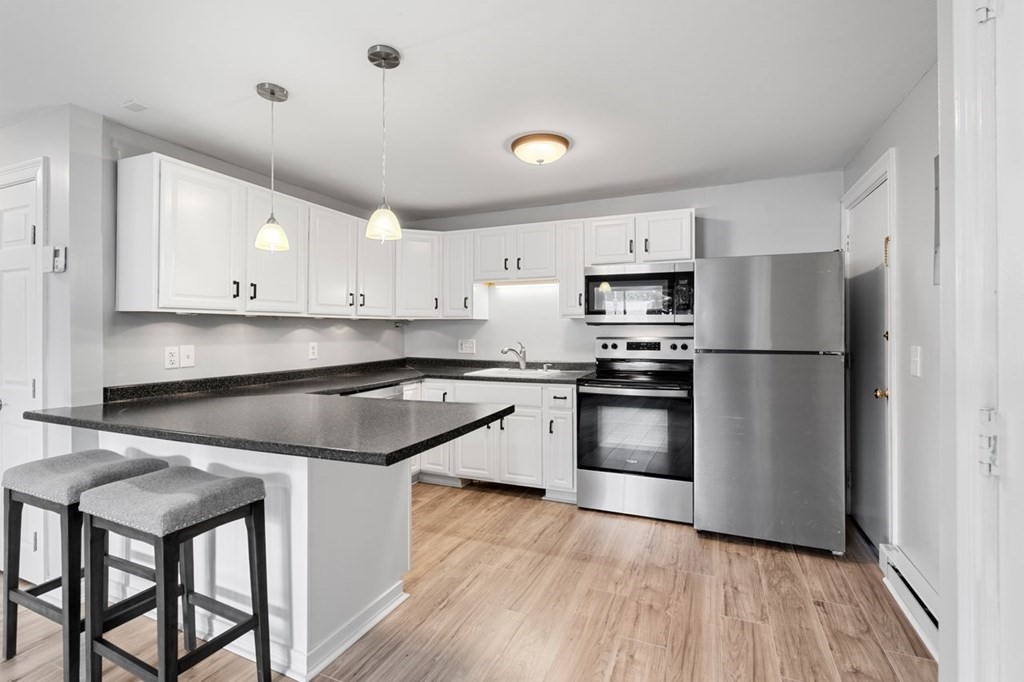 5 Turnpike Road, Unit 210 Townsend, MA 01469 - Photo 1 of 29 a kitchen with granite countertop a refrigerator stove and microwave