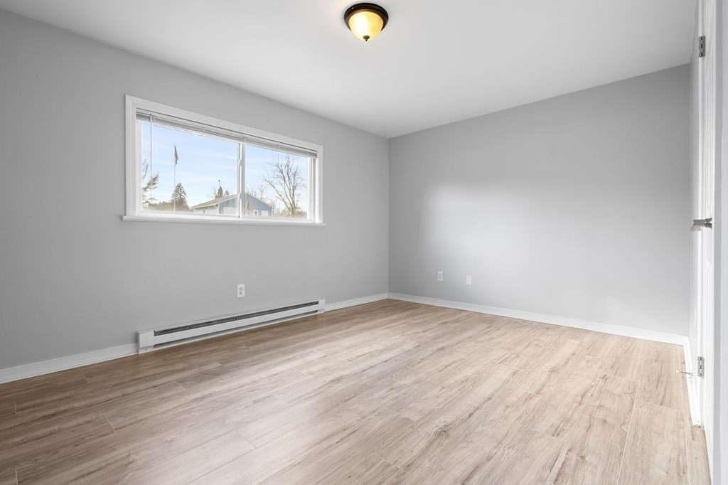 5 Turnpike Road, Unit 210 Townsend, MA 01469 - Photo 13 of 29 a view of an empty room with wooden floor and a window