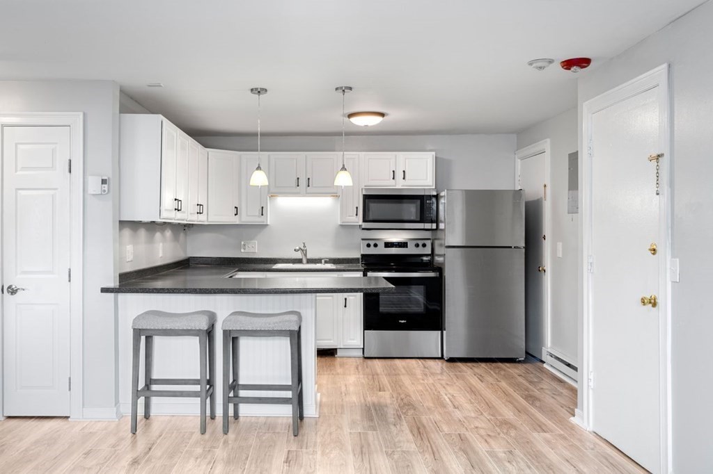 5 Turnpike Road, Unit 210 Townsend, MA 01469 - Photo 2 of 29 a kitchen with white cabinets and stainless steel appliances