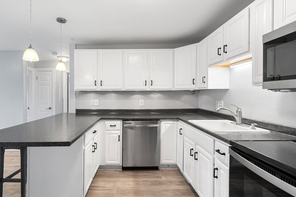 5 Turnpike Road, Unit 210 Townsend, MA 01469 - Photo 3 of 29 a kitchen with granite countertop white cabinets stainless steel appliances and a sink