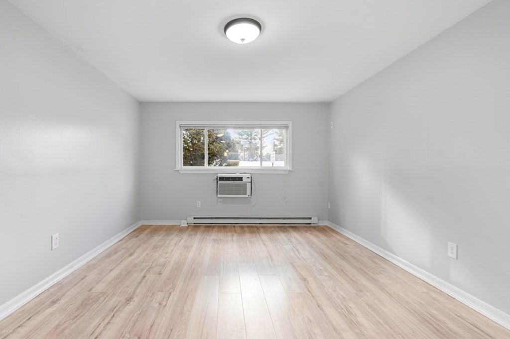 5 Turnpike Road, Unit 210 Townsend, MA 01469 - Photo 8 of 29 an empty room with wooden floor and windows