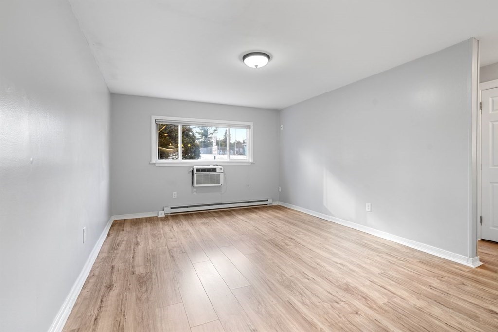 5 Turnpike Road, Unit 210 Townsend, MA 01469 - Photo 9 of 29 an empty room with wooden floor and windows