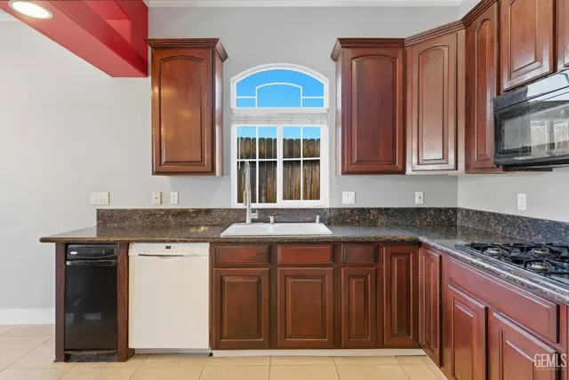 an empty room with chandelier fan and windows