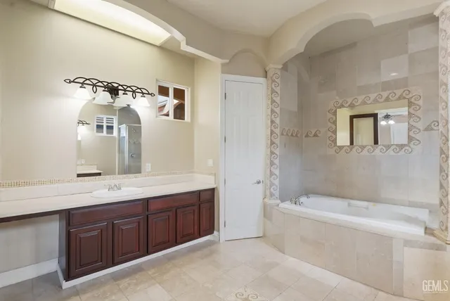 a bathroom with a tub a sink and mirror