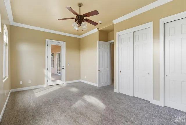 a view of a hallway with a chandelier fan and windows