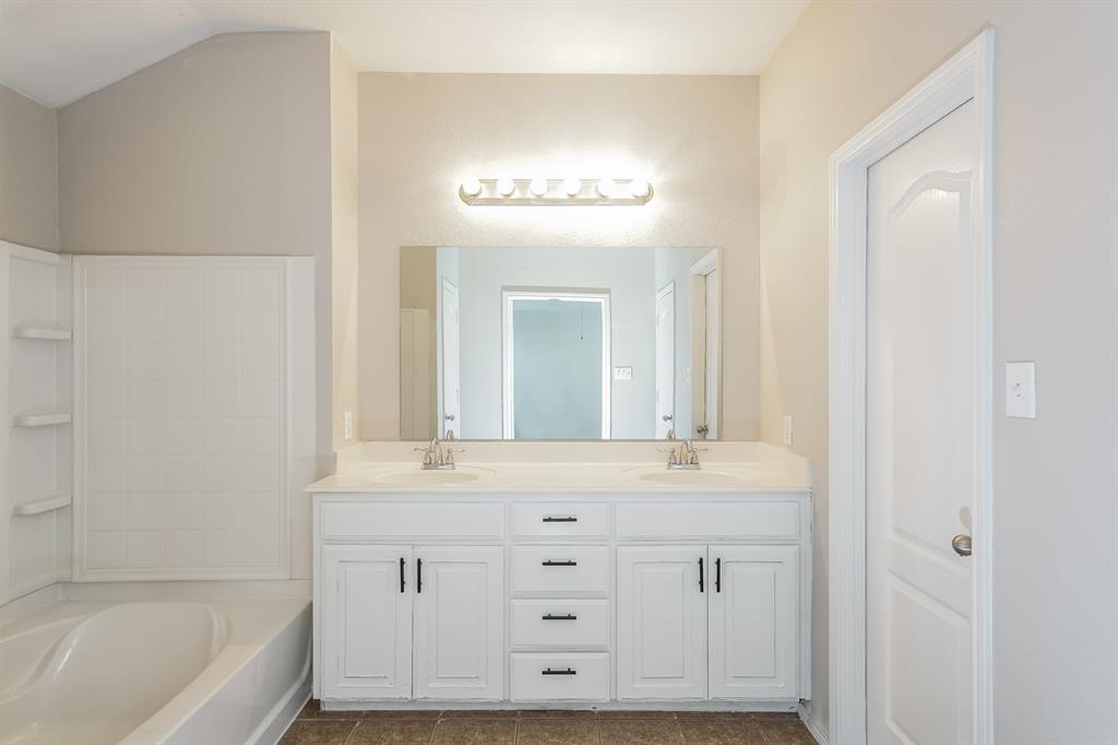 2016 Cattle Creek Road Fort Worth, TX 76134 - Photo 13 of 15 a bathroom with a bathtub a double vanity sink and mirror