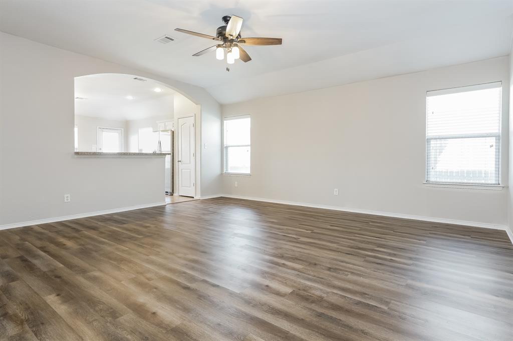 2016 Cattle Creek Road Fort Worth, TX 76134 - Photo 3 of 15 an empty room with wooden floor chandelier fan and windows