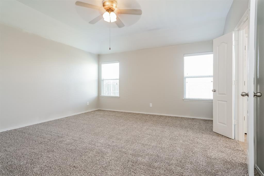 2016 Cattle Creek Road Fort Worth, TX 76134 - Photo 8 of 15 an empty room with a chandelier fan and windows